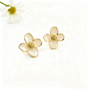 Detailed macro view of cream enamel four-petal flower earrings with 18k gold plating