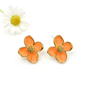 Macro detail of four-petal orange enamel flower earrings with gold-plated metallic core