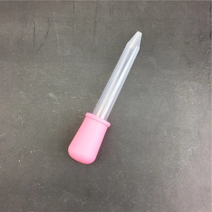 Pipetta in silicone rosa da 5ml per oli essenziali con tubo di plastica su sfondo grigio