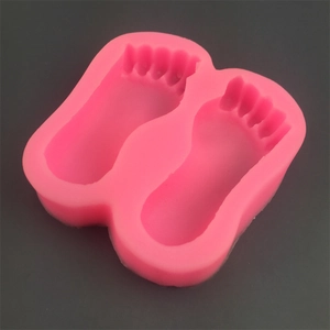 Detailed view of pink silicone mold featuring two footprint cavities for cake and DIY crafts