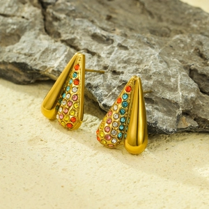 Makro-Detail von Tropfen-Ohrringen in Gold mit glatter Oberfläche und bunten Zirkonia