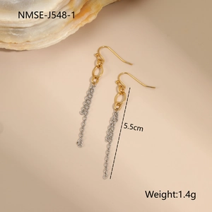 Detailed macro view of long 5.5cm gold and silver chain tassel earrings on beige background