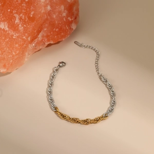 Close-up of two-tone twisted chain bracelet in gold and silver with lobster clasp