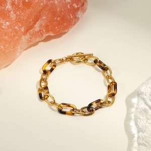 Vue détaillée du bracelet en résine ambrée et acier inoxydable doré avec fermoir à bascule