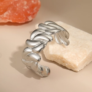 Detail shot of heavy duty silver steel open cuff bracelet with snake texture on white rock