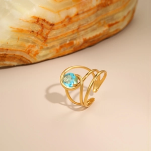 Detailed close-up of 18K gold-plated irregular spiral ring with blue zircon inlay
