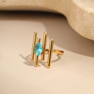 Detail of 18K gold-plated stainless steel ring with hollow geometry and blue zircon