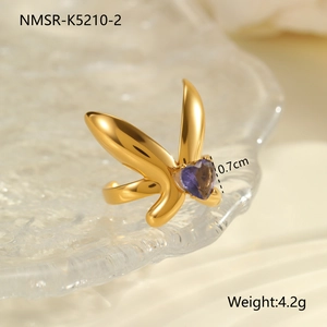 Detail of gold butterfly ring with purple heart gemstone on wave glass tray