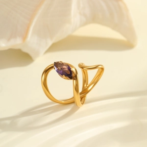 Detail of gold spiral open ring featuring a marquise-cut purple gemstone and zircon