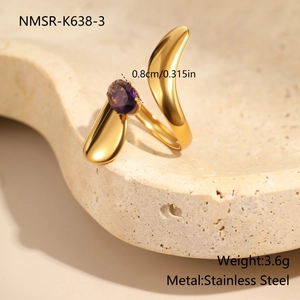 Detailed macro view of an irregular gold stainless steel ring with a purple zircon gem
