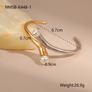 Detail view of two-tone stainless steel open bangle with elegant white pearls