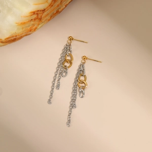 Two-tone tassel chain earrings with gold studs and silver fringes on beige background