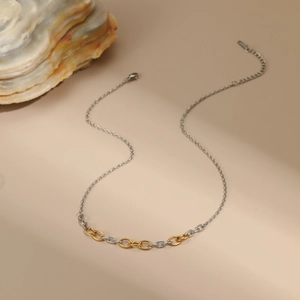 Detail of two-tone gold and silver chain necklace with lobster clasp and extension link