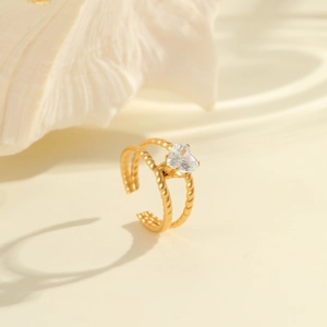 Detail of 18K gold-plated adjustable ring featuring a twisted band and heart zircon stone