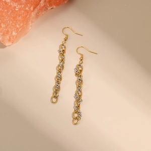 Detail of two-tone gold and silver chain link earrings on a warm beige background