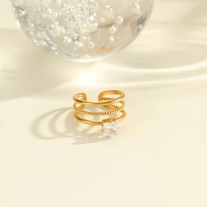 Detail of adjustable gold-plated triple band ring with a sparkling square zircon stone