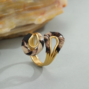 Gouden meerlaagse ring met luipaardprint en strass-steentjes op natuursteen achtergrond