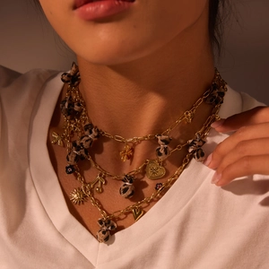 Gelaagde gouden ketting met luipaardprint en hangers in de vorm van hart en bloem