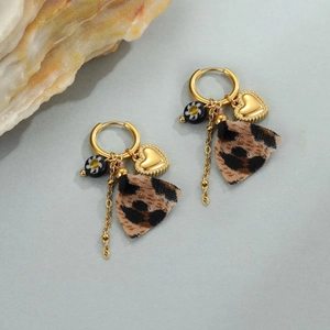 Platte weergave van luipaardprint franje oorbellen met gouden hartbedeltjes in boho-stijl