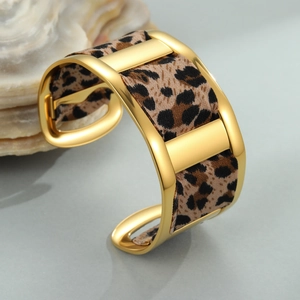 Polished 18K gold plated cuff bracelet featuring a bold leopard print ribbon inlay