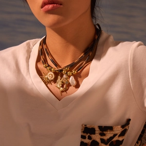 Gelaagde ketting met luipaardprint leer en goudkleurige zon-, vogel- en parelhanger