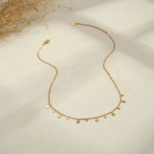 Detailed shot of golden Y-necklace with small teardrop pendants and lobster clasp closure