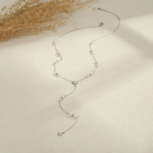 Elegant silver stainless steel Y-necklace with pearls and star charms on beige surface