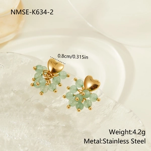 Detail of beaded cluster earrings with gold heart stud and green stones in stainless steel