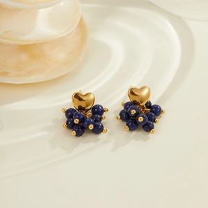 Vintage gold heart earrings with dark blue stone beads on elegant white stand