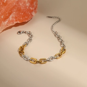 Detail van tweekleurige goud en zilveren ketting met karabijnsluiting en verlenging