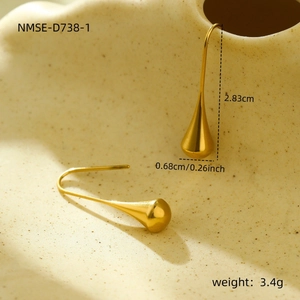 Détails de boucles d'oreilles pampilles gouttes dorées sur une surface en céramique