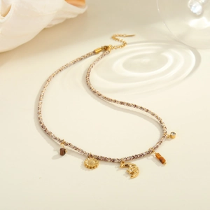 Detalle del collar bohemio de cuerda trenzada con colgantes de girasol y luna creciente