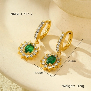 Macro shot of 18K gold earrings with emerald green zircon showing size and weight details