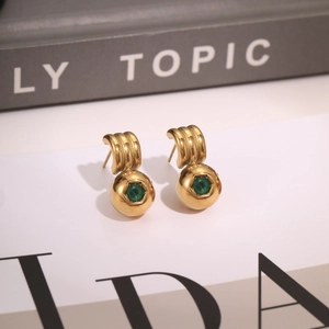 Detail of 18K gold-plated ball earring with an emerald-green zircon inlay and ribbed C-hook