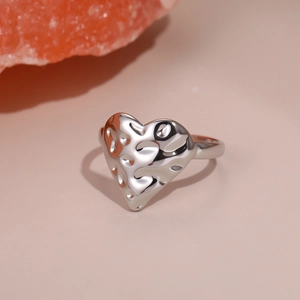 Detail of silver heart ring with irregular hammered lava texture and glossy finish