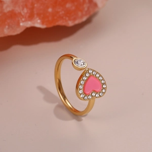 Detailed macro view of an 18K gold-plated heart ring with a pink enamel finish and zircon