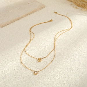 Collar de doble capa en acero inoxidable dorado con colgantes geométricos de cristales