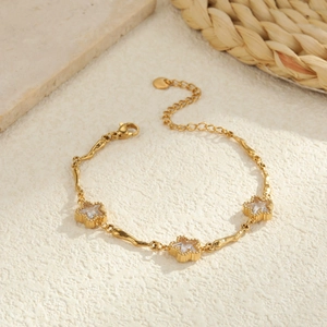 Gouden sterrenarmband met zirkoon bedeltjes en verstelbare sluiting op stenen achtergrond