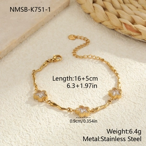 Detail van een gouden roestvrijstalen armband met drie sterbedels en zirkonia-inzetstukken
