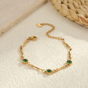 Elegante gouden roestvrijstalen armband met drie ronde groene smaragd-zirkonia stenen