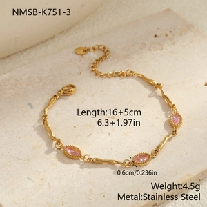 Detail van gouden roestvrijstalen armband met roze zirkonen op stenen oppervlak