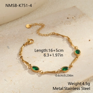 Detail van de goudkleurige roestvrijstalen armband met drie groene zirkonia en parelrand