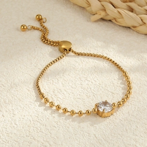 Detail of gold bead bracelet with cubic zirconia center and adjustable bolo clasp closure