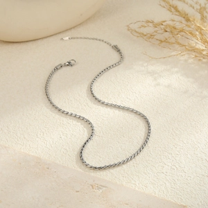 Dettaglio ravvicinato di una collana a corda argentata con chiusura a moschettone