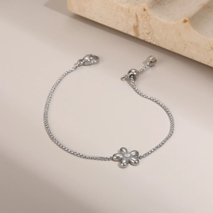 Macro view of adjustable stainless steel bracelet with a crystal flower pendant