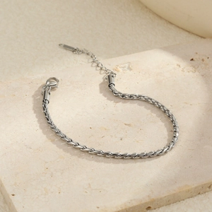Dettaglio macro della catena a spiga argento con chiusura a moschettone e catenella