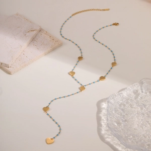 Elegante collar en Y de acero de titanio dorado con corazones y cuentas turquesas