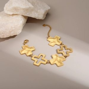 Detail eines 18k Gold Kreuz-Armbands mit Hammerschlag-Textur und Karabinerverschluss
