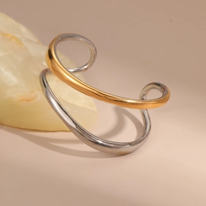 Detail shot of a two-tone twisted cuff bracelet with high-polish gold and silver finish