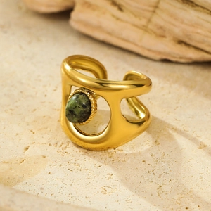 Macro detail van vergulde roestvrijstalen ring met ovale groene natuursteen inleg